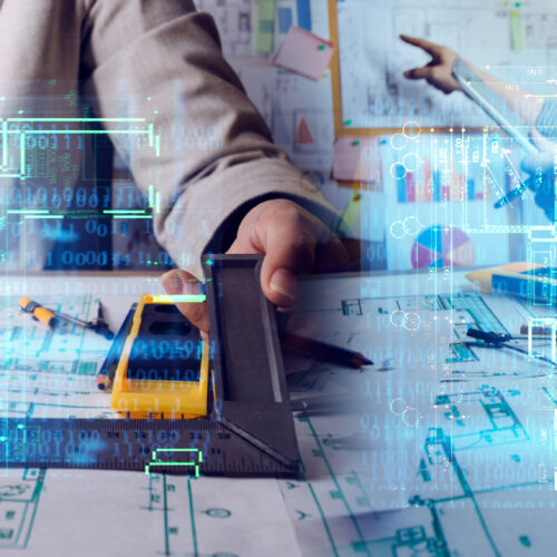 A tabletop showing blueprints with two people at the table